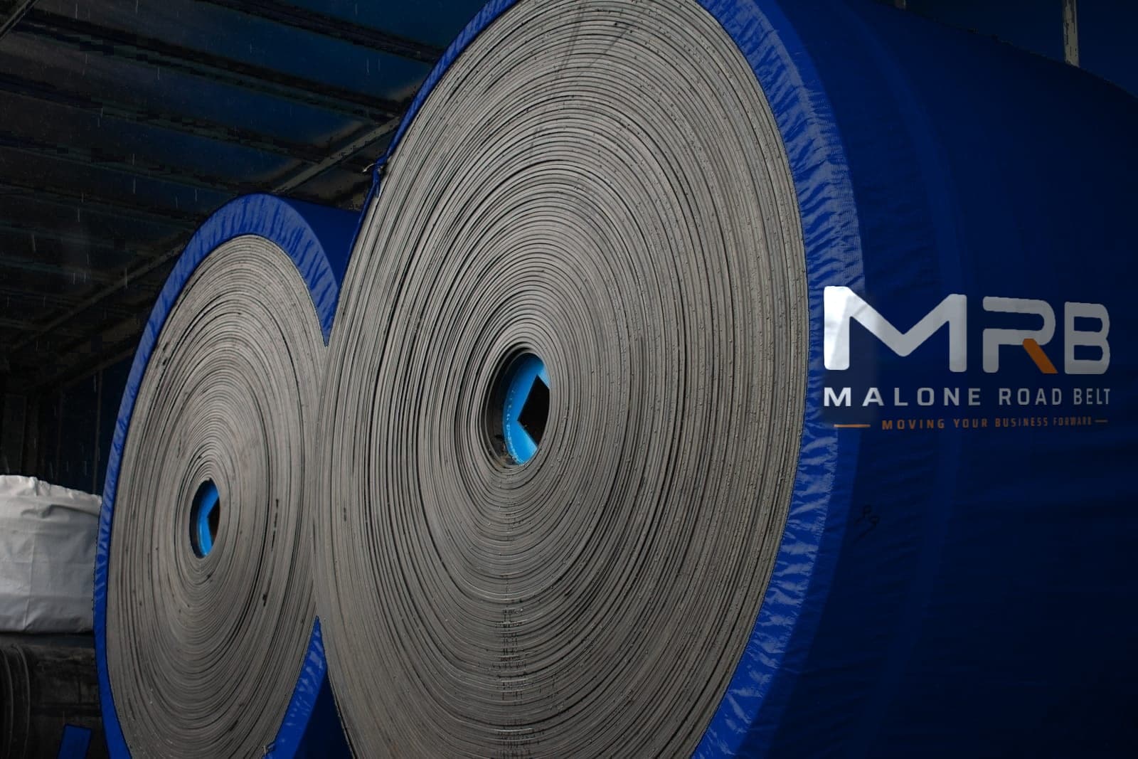 Finished conveyor belt rolls wrapped for dispatch in the warehouse